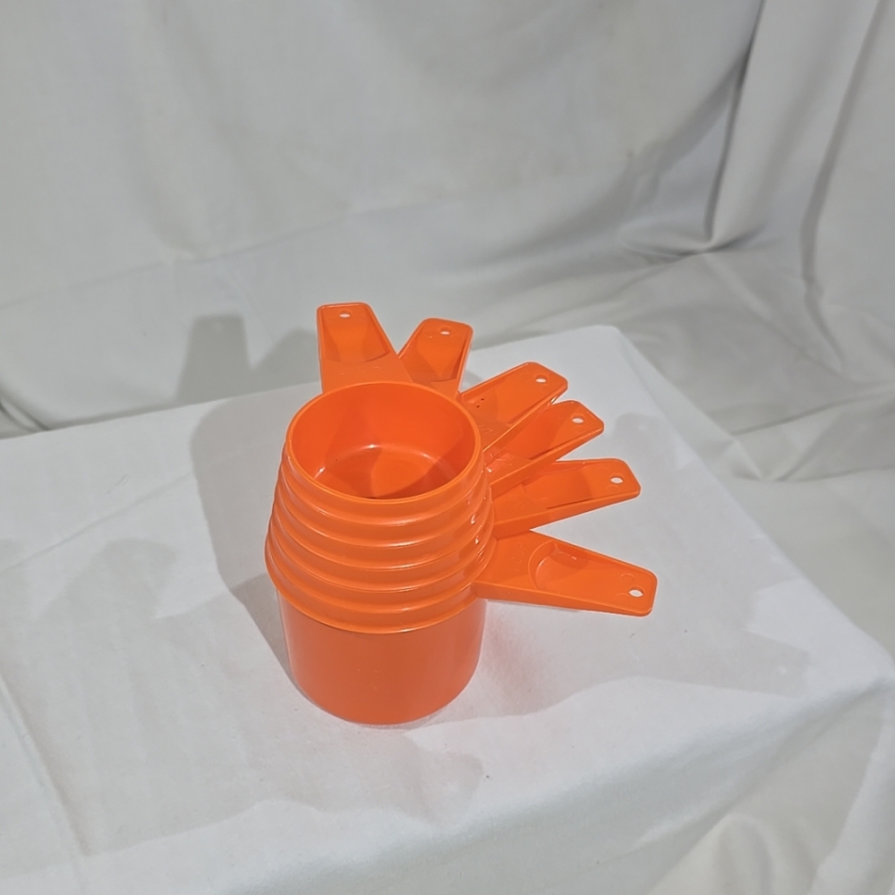 Vintage orange Tupperware measuring cup set.